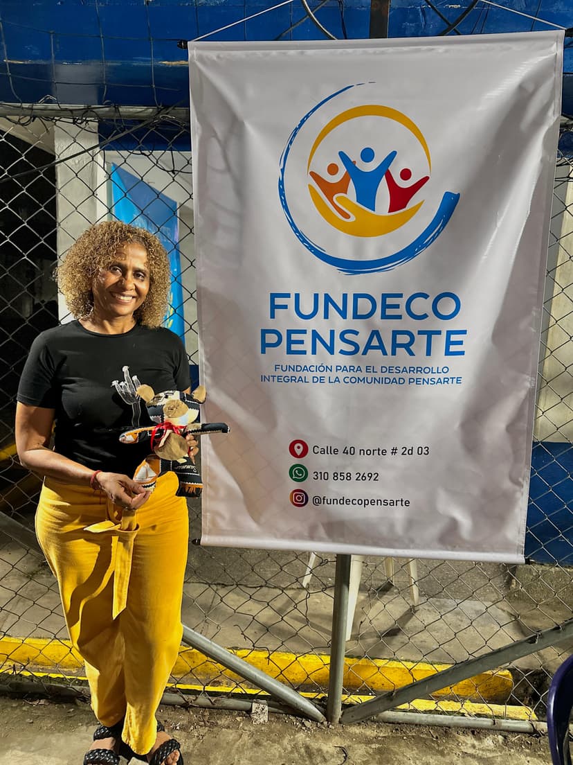 Mujer con un peluche frente a un pendón de Fundeco pensarte