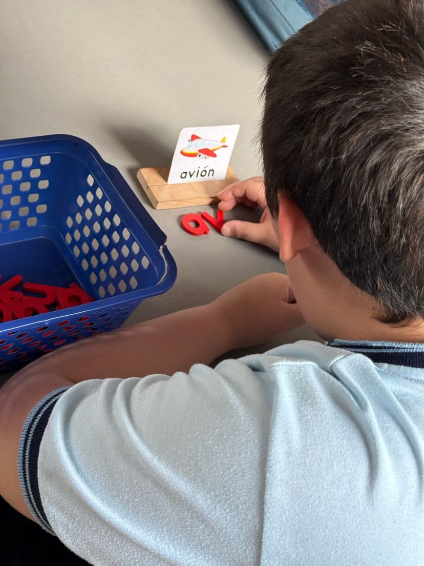 Niño con escribiendo con letras de madera