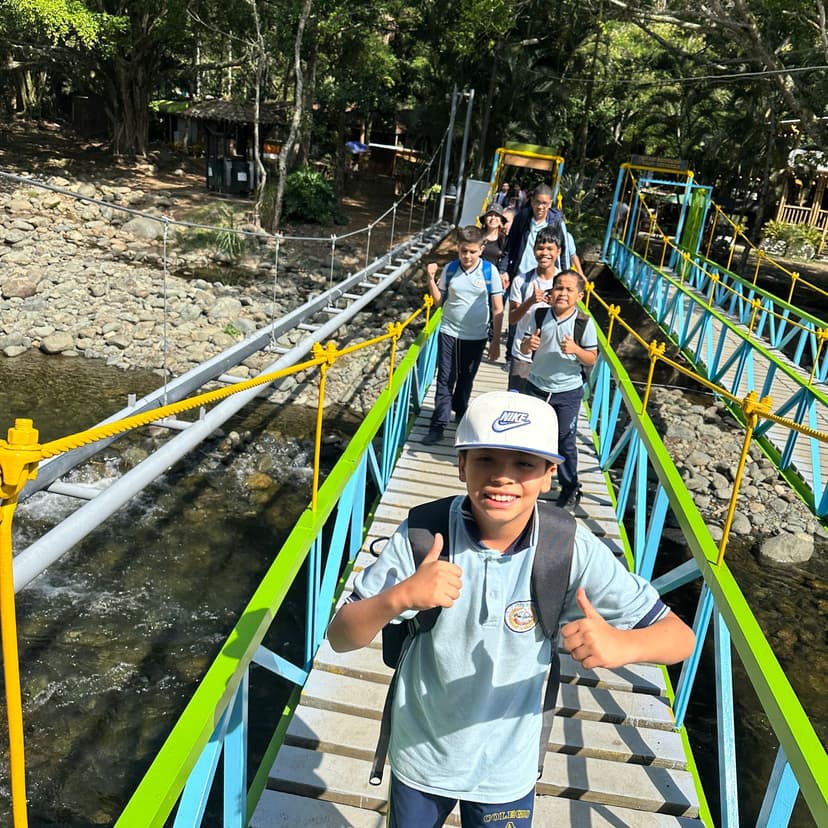 Niños atravesando un río por encima de un puente.